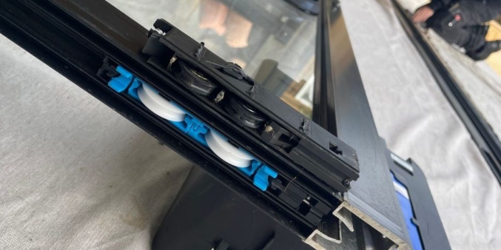 Worn sliding door roller removed during a repair